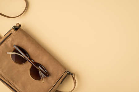 Top view photo of leather bag satchel on isolated beige background with copyspace