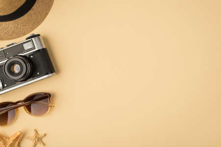 Top view photo of hat camera sunglasses and starfishes on isolated beige background with copyspace