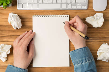 Overhead photo of blank notepad paper hands pen plant computer keyboard and mouse isolated on the...