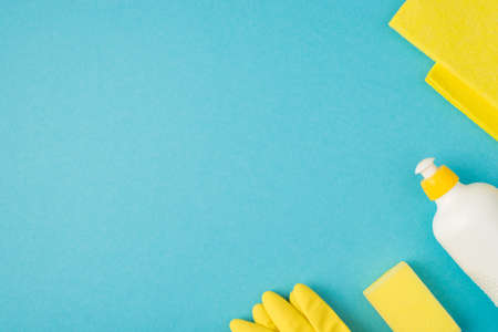 Above photo of soap cleaning rag and yellow gloves isolated on the blue backgroundの写真素材