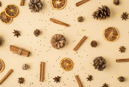 Top view scattered pine cones anise dried lemon slices cinnamon sticks and golden sequins