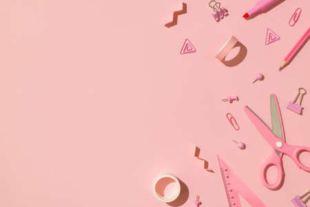 Top view photo of school accessories pink stationery adhesive tapes pins binder clips scissors pencil felt pen and ruler on isolated light pink background with copyspaceの写真素材