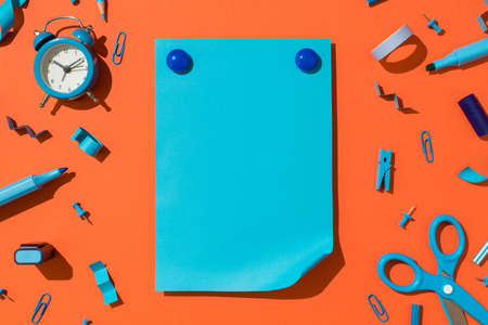 Top view photo of round plastic covered magnets on vivid blue sheet of paper with curled corner and...