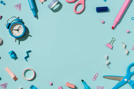 Top view photo of bicolor blue and pink school supplies felt pens binder clips pins eraser adhesive...