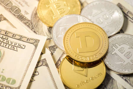 Closeup photo of gold and silver coins with dogecoin bitcoin and ethereum symbols on hundred dollar...
