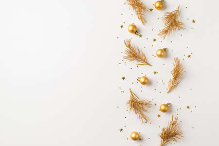 Top view photo of row composition golden christmas tree decorations small balls pine branches and confetti on isolated white background with copyspaceの写真素材
