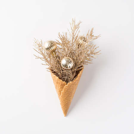 Top view photo of ice cream cone with pine branches and silver christmas tree balls on isolated white backgroundの写真素材
