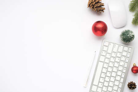 Top view photo of keyboard computer mouse pen red christmas tree balls fir toy twig pine cone on...