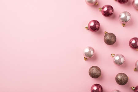 Top view photo of pink christmas tree decorations balls on isolated pastel pink background with empty spaceの写真素材