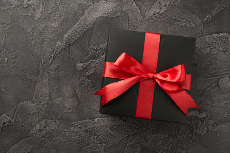 Top view photo of valentine's day decorations black giftbox with red silk ribbon bow on isolated...