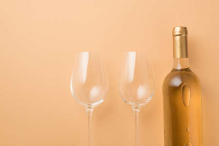 Top view photo of saint valentine's day decorations bottle of white wine and two wineglasses on isolated pastel beige background with copyspaceの写真素材