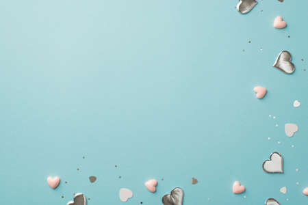 Top view photo of valentine's day decorations silver and pink hearts confetti and sequins on...