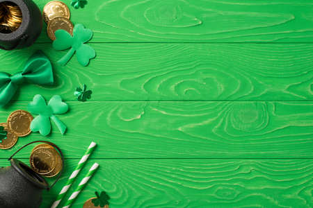 Top view photo of the black pots with many coins inside and around two stripped straws soft confetti...
