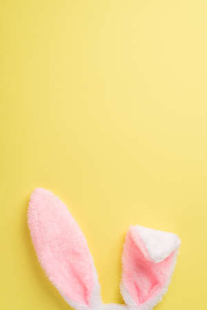 Top view of cute fluffy headband in shape of rabbits ears on the isolated yellow background copyspaceの写真素材