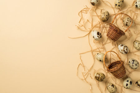 Top view of many eggs with brown spots different size and two small wicker baskets situated on straw...