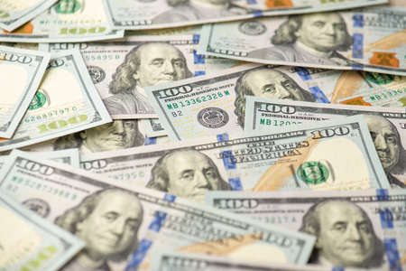 Photo of a pile of one hundred dollar banknotesの写真素材
