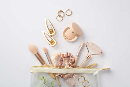 Top view photo of blast of hairpins rose quartz roller gold rings makeup brushes scrunchies and...