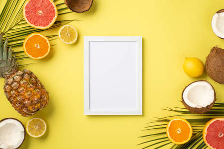 Summer vacation concept. Top view photo of white photo frame tropical fruits cracked coconuts cut...
