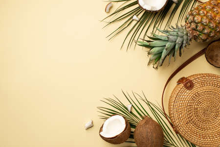 Summer holidays concept. Top view photo of round rattan handbag fresh tropical fruits cracked...