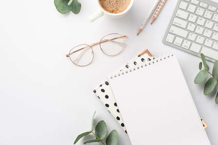 business concept. Top view photo of workplace keyboard reminders pencils cup of hot drinking stylish glasses and eucalyptus on isolated white background with blank spaceの写真素材
