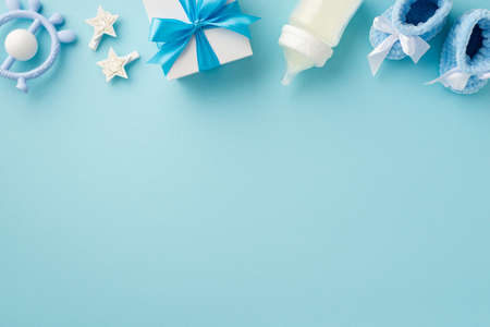 baby accessories concept. Top view photo of giftbox teether knitted booties milk bottle and stars on...