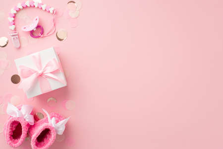 baby accessories concept. Top view photo of white giftbox with bow pacifier chain pink knitted...