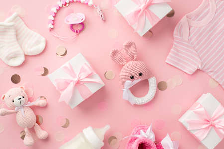 baby girl concept. Top view photo of gift boxes shirt socks knitted bunny rattle toy teddy-bear toy...