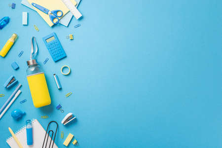 Back to school concept. Top view photo of school supplies yellow drink bottle correction pen clip...
