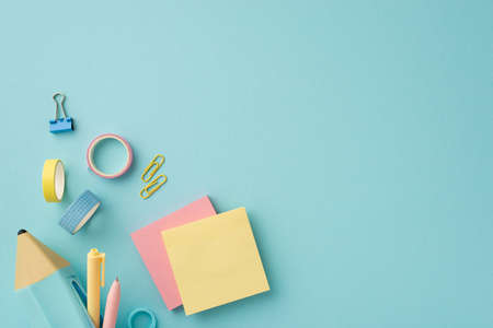 Back to school concept. Top view photo of colorful stationery blue pencil-case with pens sticky note paper adhesive tape and binder clips on isolated pastel blue background with copyspaceの写真素材