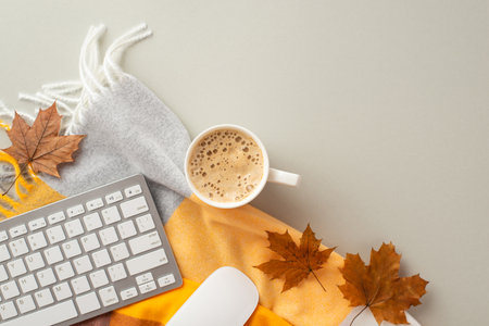 Autumn business concept. Top view photo of workplace yellow maple leaves keyboard computer mouse cup of hot drinking and plaid scarf on isolated gray backgroundの写真素材