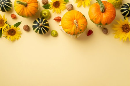Thanksgiving day concept. Top view photo of sunflowers vegetables pumpkins pattypans walnuts and physalis on isolated beige backgroundの写真素材