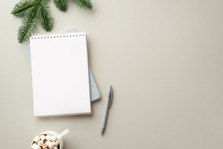 New year concept. Top view photo of open notebook pen mug of beverage with marshmallow and pine branch on isolated gray background with copyspaceの写真素材