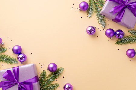 Christmas Eve concept. Top view photo of lilac gift boxes with bows violet baubles pine branches in snow and purple sequins on isolated pastel beige background with empty spaceの写真素材