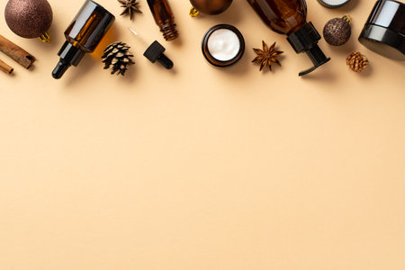 natural cosmetics concept. Top view photo of amber glass bottles brown baubles pine cones cinnamon sticks and anise on isolated beige background with blank spaceの写真素材