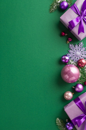 Christmas Eve concept. Top view vertical photo of lilac gift boxes with bows violet and pink baubles fir branches in hoarfrost and snowflake ornament on isolated green background with empty spaceの写真素材
