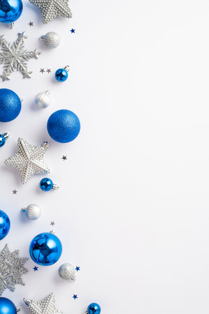 Christmas decoration concept. Top view vertical photo of blue white silver baubles snowflake star ornaments and confetti on isolated white background with copyspaceの写真素材