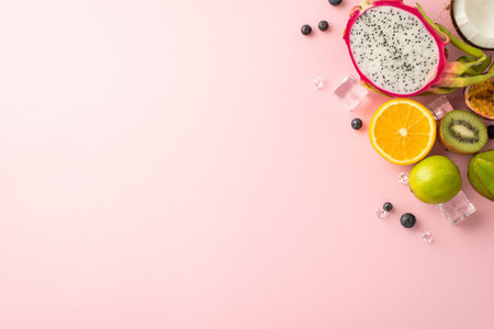 Fruity summer delights. A colorful flat lay top view of exotic fruits dragon fruit kiwi, orange, lime, passion fruit carambola and coconut on a pink background and an empty circle for promotional textの写真素材