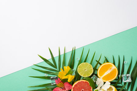 Zesty fruit concept. Top view flat lay of alstroemeria flowers with tangy grapefruit, orange, and lime slices on white teal background with empty space for text or advertの写真素材