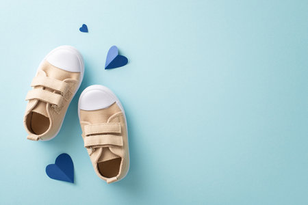 Little son celebrate dad on Father's Day. Top view of baby's sneakers, and hearts on pastel blue background with empty spaceの写真素材