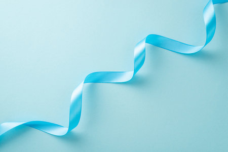 Top view photo of light blue twisted ribbon on a pastel background with copy-spaceの写真素材