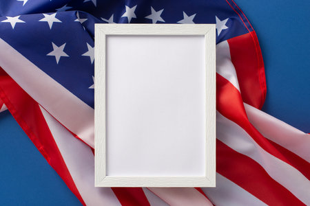 american federal holiday concept. High angle view photo of rectangular wooden frame on american flag on blue isolated background with copy-spaceの写真素材