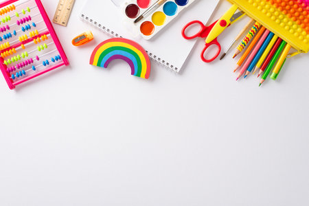 Explore wonders of early childhood education with this top-down perspective: arrangement of colorful child stationery on white isolated background, providing copyspace for text or promotional materialの写真素材