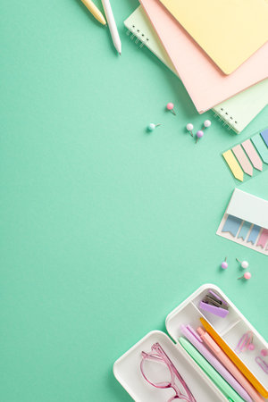 Brighten up your school routine with vibrant arrangement. Girlish stationery spread out on teal surface from vertical top view, featuring planners, pencil case, sticky notes, pins. Add own text or adの写真素材