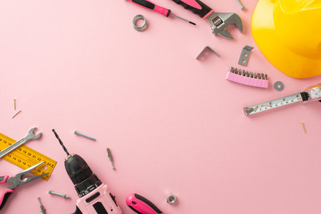 Honoring the significant role of female laborers on Labor Day. Top view snapshot capturing a set of building tools on a pink isolated backdrop, with copyspace for advertising or textの写真素材