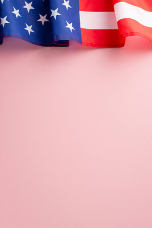 Vibrant representation of Labor Day celebration. Overhead vertical image showcasing an American flag on a pink isolated background. Copy-space available for text or promotionsの写真素材