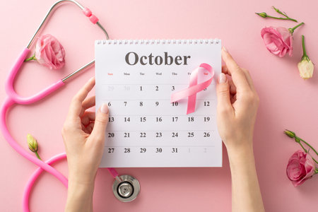 Show your support during International Breast Cancer Awareness Month. Top view picture with hands, calendar, and pink ribbon on pastel pink isolated background, suitable for text or advertisingの写真素材