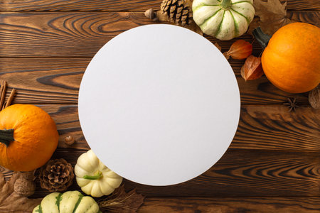 Celebrate the autumn harvest concept. Top-down image showcases ripe pumpkins and quintessential fall items on a dark wooden background, leaving space for text or ads to enhance the themeの写真素材