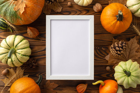 Embrace the autumn harvest season with this top-down image. Rich pumpkins, maple leaves and wheat arranged on a dark wooden surface, offering ample copy-space for your text or advertisementsの写真素材