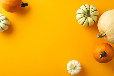 Harvest season showcase: Overhead glimpse of pumpkins, gourd, pattipans against an orange...