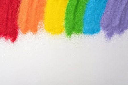 Celebrate LGBT history month with sand flag art. Top view showcases a rainbow flag made from sand on...